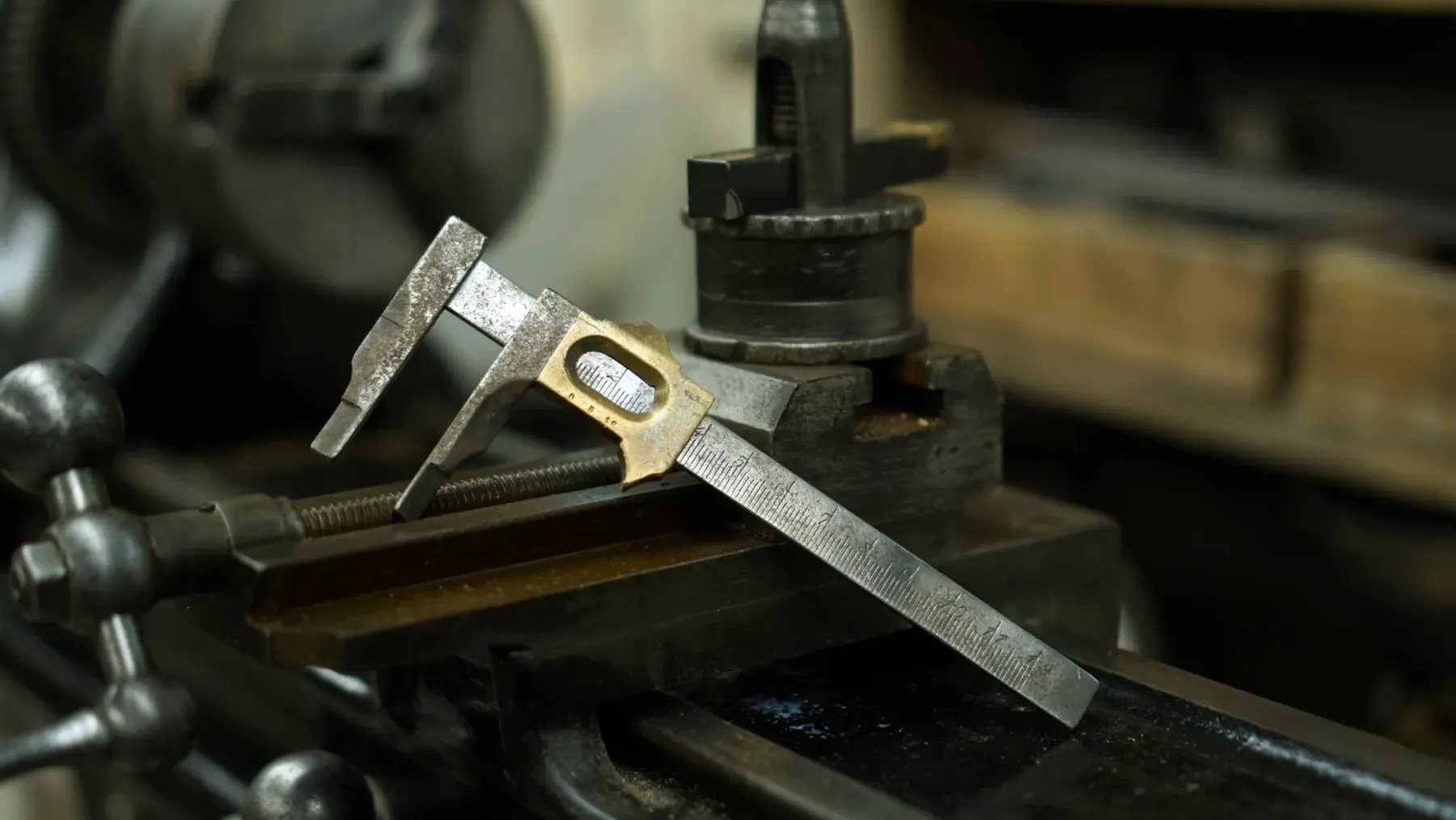 A calliper resting on a lathe in a workshop